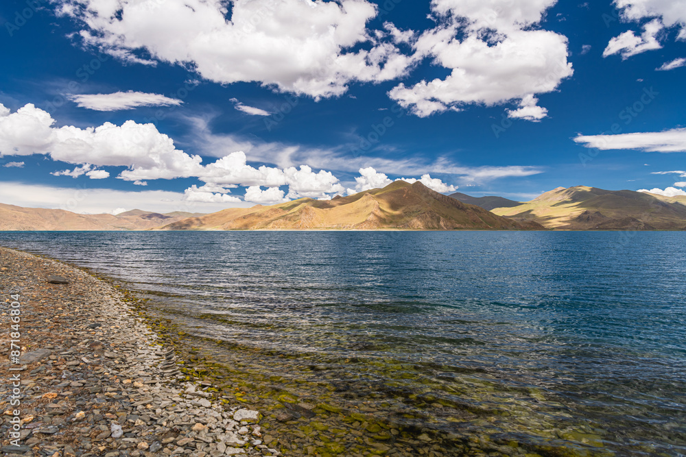 Shadow of Cloud over the clear turquoise lake, at Yamdrok Lake, Tibet, China. Copy space for text Shadow of Cloud over the clear turquoise lake, at Yamdrok Lake, Tibet, China. Copy space for text