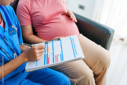 Asian female doctor and nurse perform an ultrasound on a pregnant woman, using a stethoscope and medical equipment, ensuring her health and preparing for a successful birth. photo