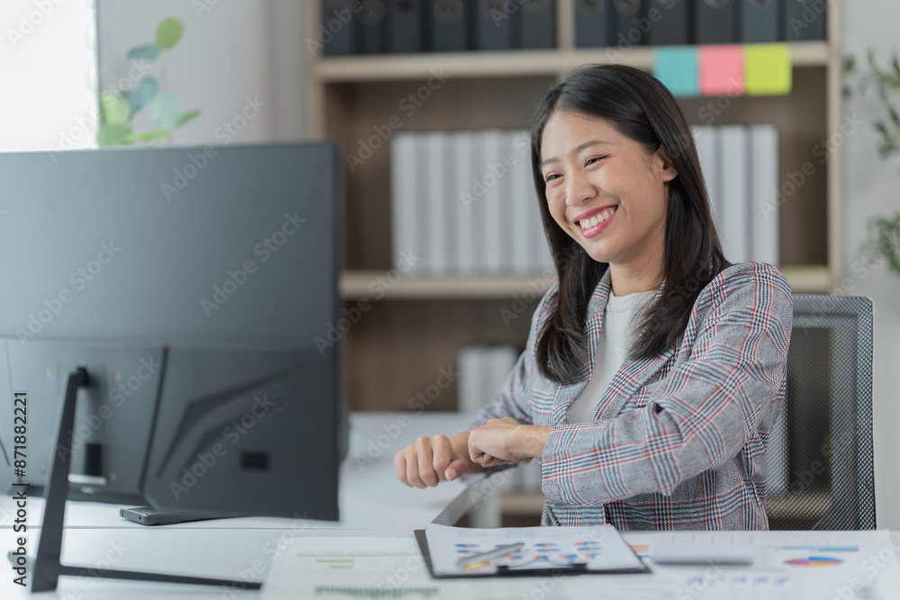 Sharing good business news. Attractive young businesswoman talking on the mobile phone and smiling while sitting at her working place in office and looking at laptop PC. Sharing good business news. Attractive young businesswoman talking on the mobile phone and smiling while sitting at her working place in office and looking at laptop PC.