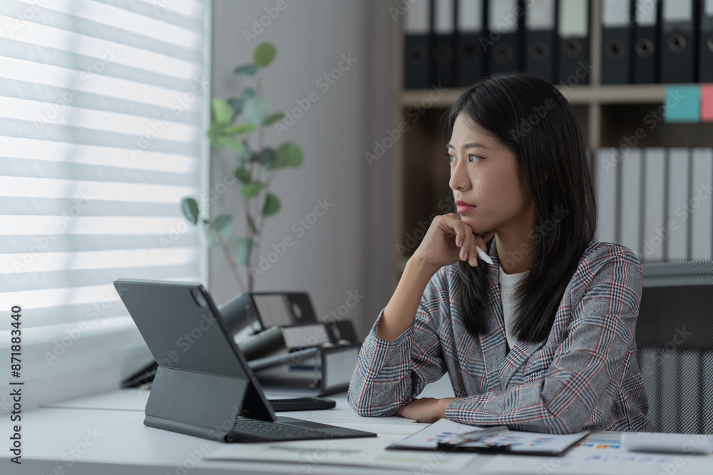 Sharing good business news. Attractive young businesswoman talking on the mobile phone and smiling while sitting at her working place in office and looking at laptop PC. Sharing good business news. Attractive young businesswoman talking on the mobile phone and smiling while sitting at her working place in office and looking at laptop PC.