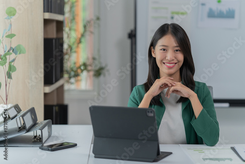 mage of a young Asian businesswoman holding a credit card. © Tj