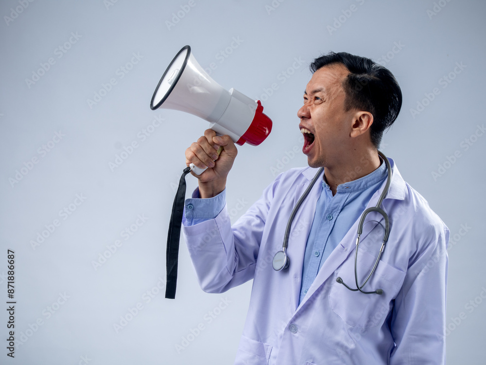 Asian male doctor in a white coat holding a megaphone and speaking enthusiastically. The plain background emphasizes the focus on the doctor's energetic announcement and the stethoscope Asian male doctor in a white coat holding a megaphone and speaking enthusiastically. The plain background emphasizes the focus on the doctor's energetic announcement and the stethoscope