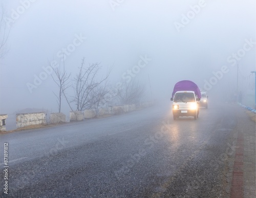 Vehicles on Foggy Road with Headlights On
 photo