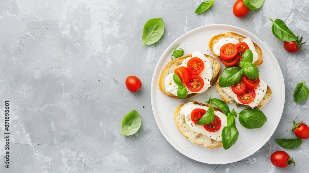 Four pieces of toasted bread topped with fresh mozzarella, sliced tomatoes, and basil leaves Four pieces of toasted bread topped with fresh mozzarella, sliced tomatoes, and basil leaves