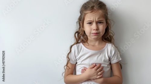 Little girl with a stomach ache, holding their stomach in pain on white background