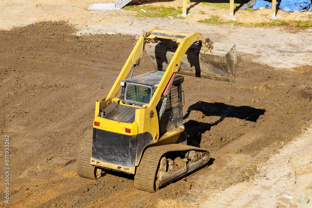 Construction work is being carried out in backyard using tractor to leveling ground Construction work is being carried out in backyard using tractor to leveling ground