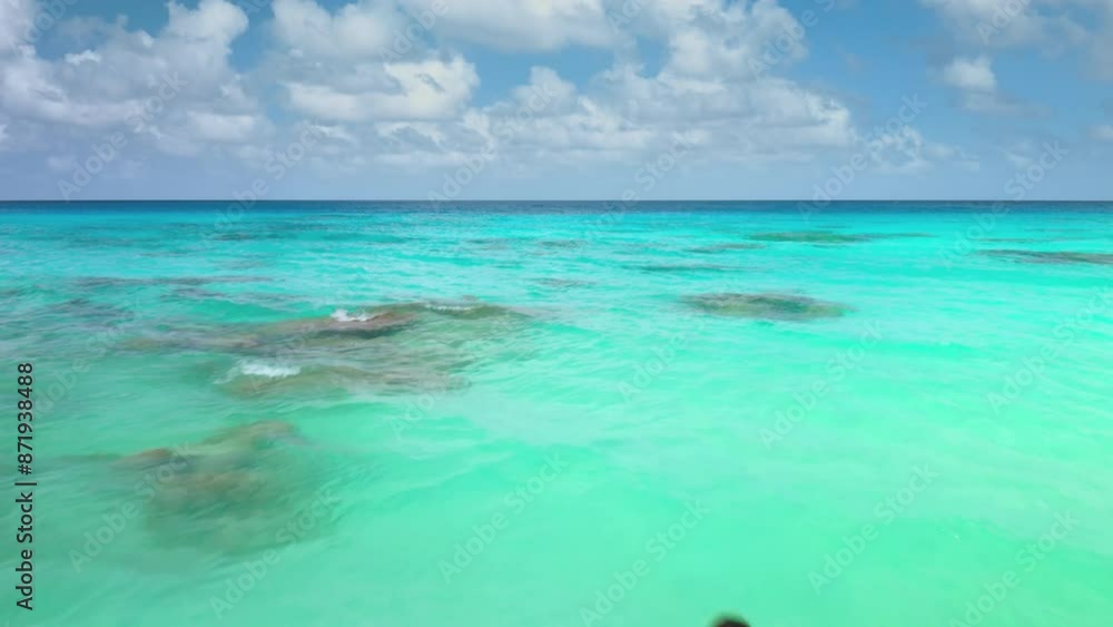 Young woman in black bikini swim crystal clear, turquoise water lagoon in French Polynesia. Bright blue sky and white clouds above. Scene of idyllic summer holiday vacation, beauty tropical paradise Young woman in black bikini swim crystal clear, turquoise water lagoon in French Polynesia. Bright blue sky and white clouds above. Scene of idyllic summer holiday vacation, beauty tropical paradise