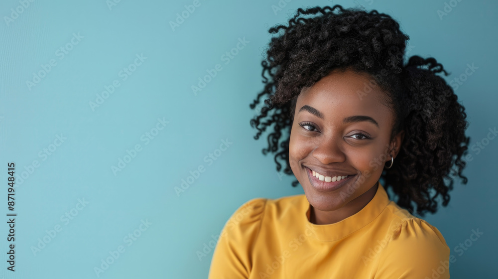 A joyful young woman poses with a charming smile, wearing a bright yellow blouse against a soothing blue background A joyful young woman poses with a charming smile, wearing a bright yellow blouse against a soothing blue background