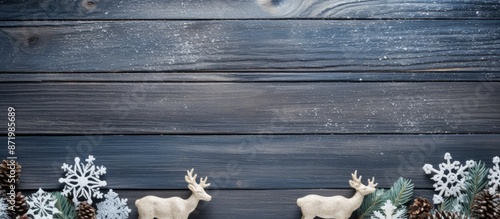 Wooden Christmas decorations like fir trees, deer, snowflakes, and horses adorn a vintage blue wooden board, creating a festive holiday postcard frame for your text and design with copy space image. photo