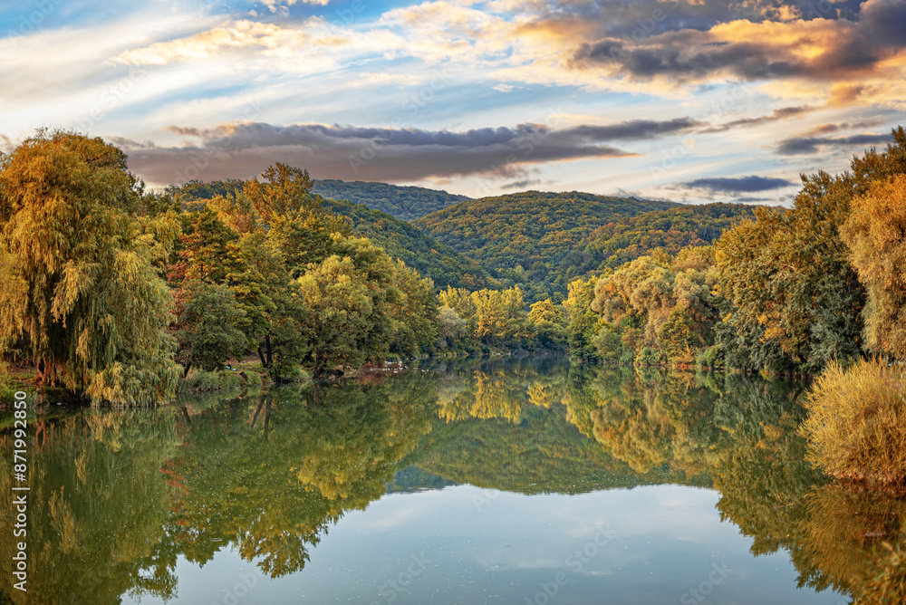 The lake on the background of the autumn forest in the rays of the sunset. The lake on the background of the autumn forest in the rays of the sunset.