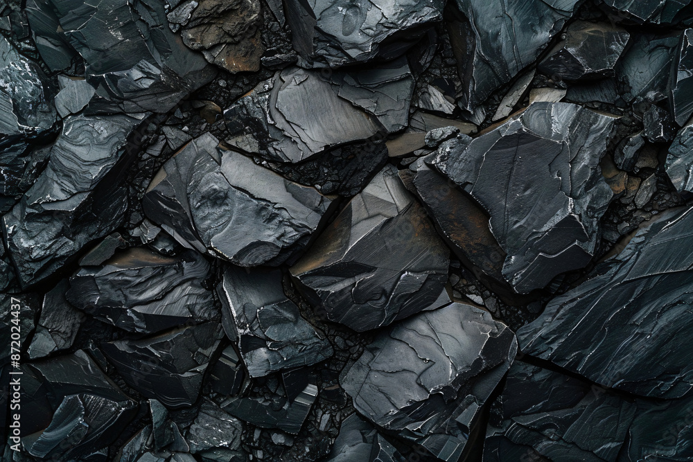 Black rock texture background, abstract dark stone wall of natural black coal and raw iron rocks with a grainy surface. Top view of heavy material for industrial design or decoration in close-up. Black rock texture background, abstract dark stone wall of natural black coal and raw iron rocks with a grainy surface. Top view of heavy material for industrial design or decoration in close-up.