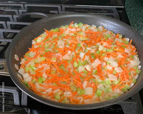 Canvas-taulu Mirepoix of onion, carrot, and celery cooking in skillet