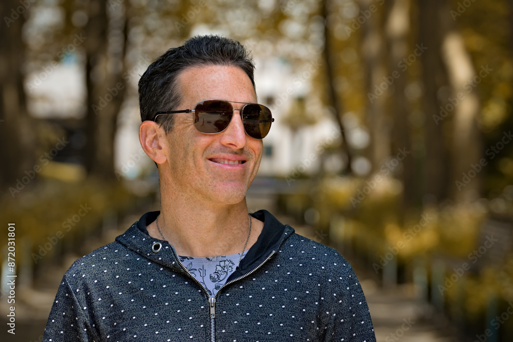 Dark haired mediterranean man smiling outdoors Dark haired mediterranean man smiling outdoors