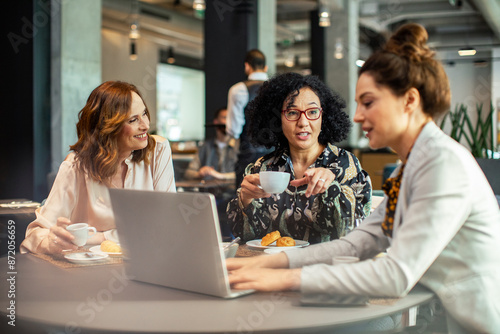 Diverse businesswomen having meeting in hotel restaurant photo