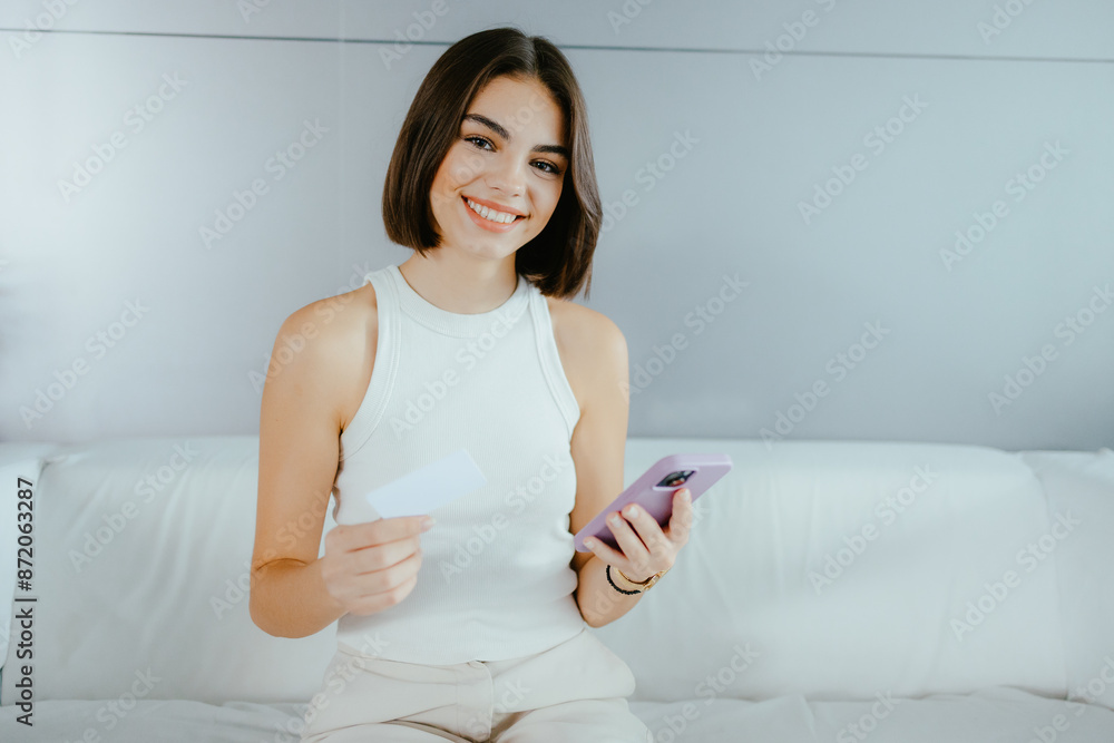 Young Woman Holding Credit Card and Smartphone Young Woman Holding Credit Card and Smartphone