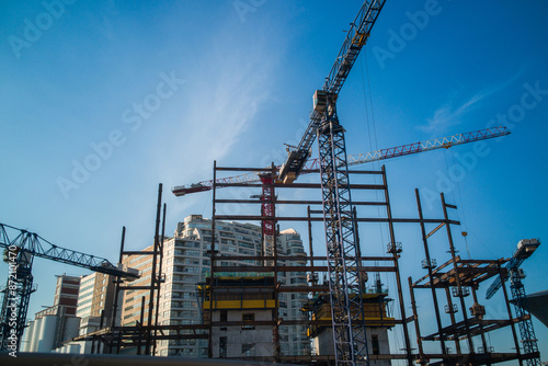 Принти на полотні Urban skyline transformation: cranes orchestrate a new cityscape.