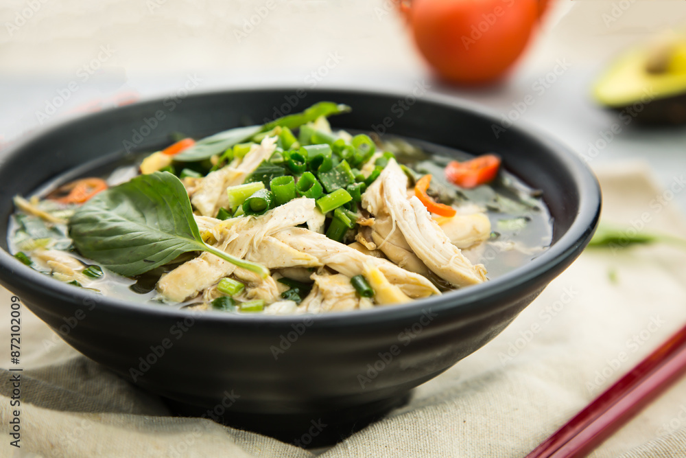 shredded chicken soup river with spring onion, and green leaves served in broth isolated on background side view of hong kong food shredded chicken soup river with spring onion, and green leaves served in broth isolated on background side view of hong kong food