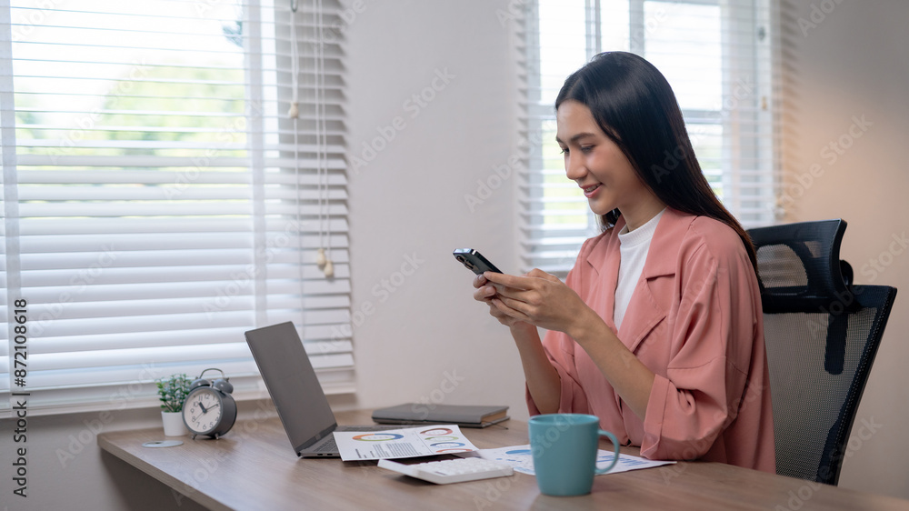 Woman working from home using a laptop and smartphone, sitting at a desk with documents and a cup of coffee, bright and airy home office. Woman working from home using a laptop and smartphone, sitting at a desk with documents and a cup of coffee, bright and airy home office.