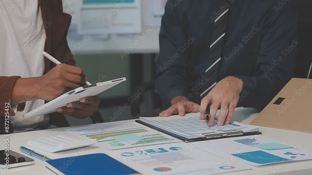 Business meeting time,business account managers crew working with new startup project,report analysis cost graph on desk at meeting room. Business meeting time,business account managers crew working with new startup project,report analysis cost graph on desk at meeting room.