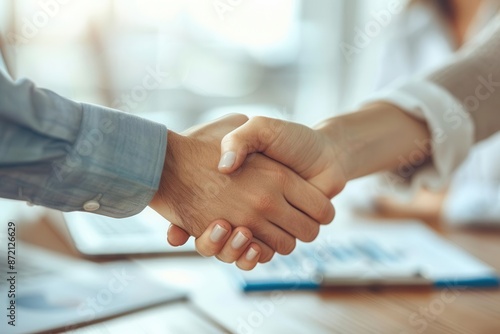 Closeup of handshake over a desk, agreement, advisorclient relationship