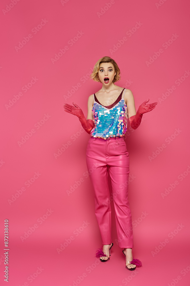 A woman in a pink outfit stands against a pink background, looking surprised. A woman in a pink outfit stands against a pink background, looking surprised.