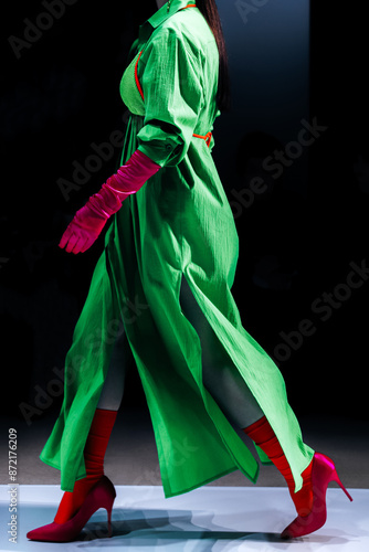 Bright green long dress, pink gloves and red high heels. Women's creative fashion design and stylish accessories. Fashion week details