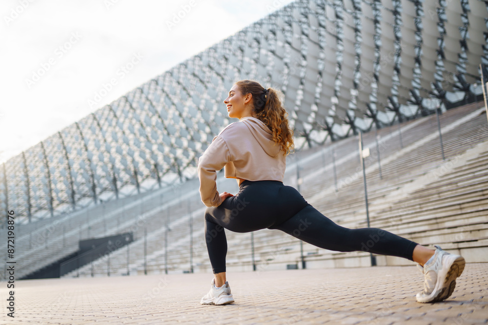 Fototapeta premium Fit woman exercising outdoors. Healthy young sportswoman doing fitness. People, sport, active and flexibility concept