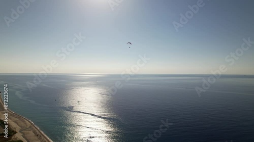 Motorized parachute. Gliding through the sky with a motorized parachute over the sea.