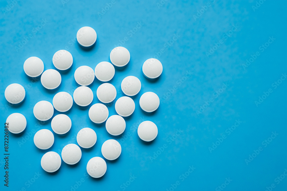 A white and blue with pills. Pharmacy pill medicine concept. Round white pills in blue on a. Round of pills in blue and white on a lifestyle. A white and blue with pills. Pharmacy pill medicine concept. Round white pills in blue on a. Round of pills in blue and white on a lifestyle.