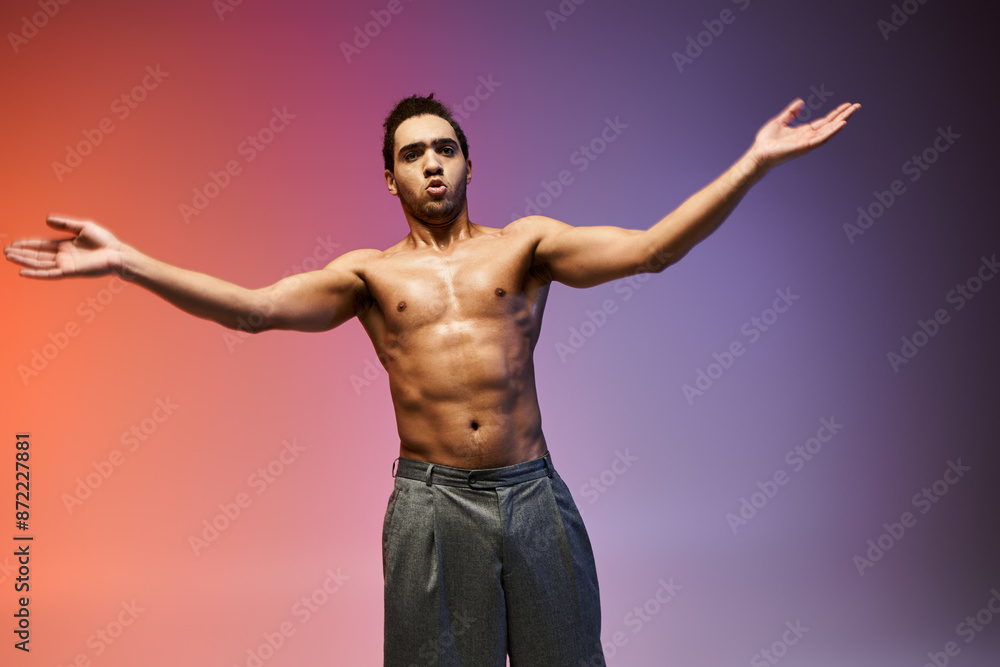 A young African American man dances with his arms outstretched against a colorful gradient background. A young African American man dances with his arms outstretched against a colorful gradient background.