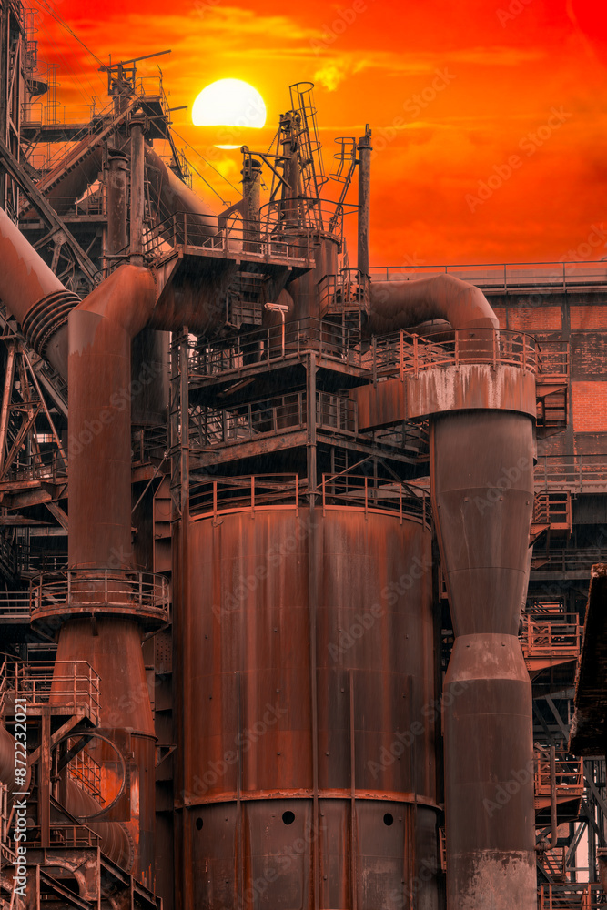 Sunset between the metal structures in a disused industry