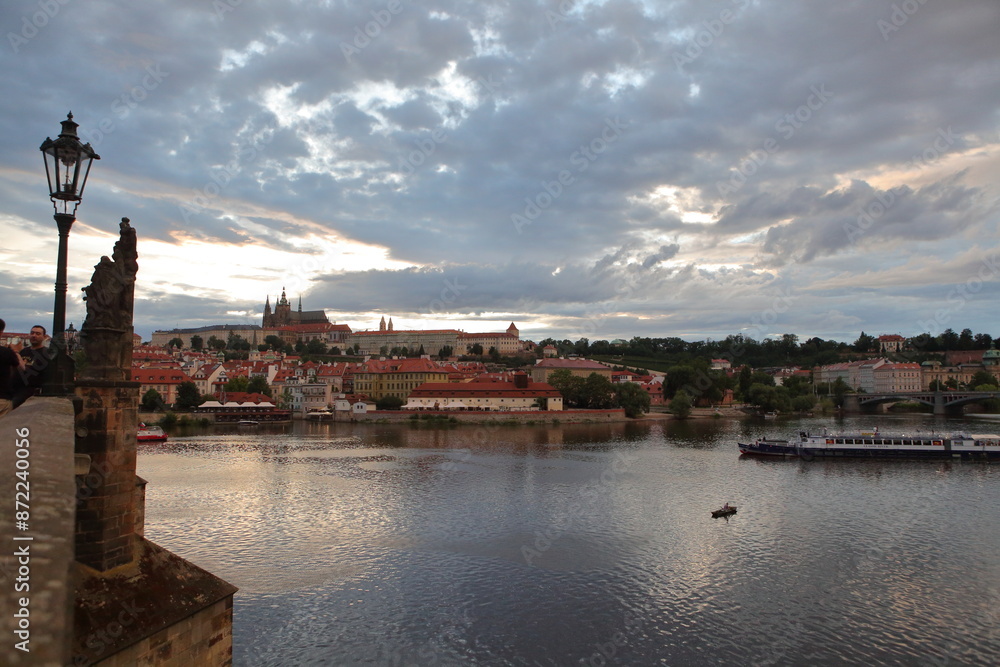 Fototapeta premium view of prague in czech republic from charles river with reflection on river and clouds. 