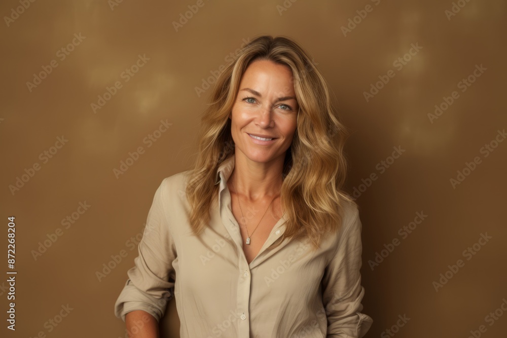 Portrait of a beautiful mature woman with long blond hair in a beige shirt Portrait of a beautiful mature woman with long blond hair in a beige shirt