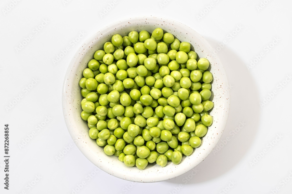 Bowl filled with fresh green peas against a white background. Bowl filled with fresh green peas against a white background.