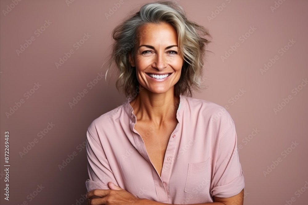 Portrait of a beautiful mature woman smiling against a pink background. Portrait of a beautiful mature woman smiling against a pink background.