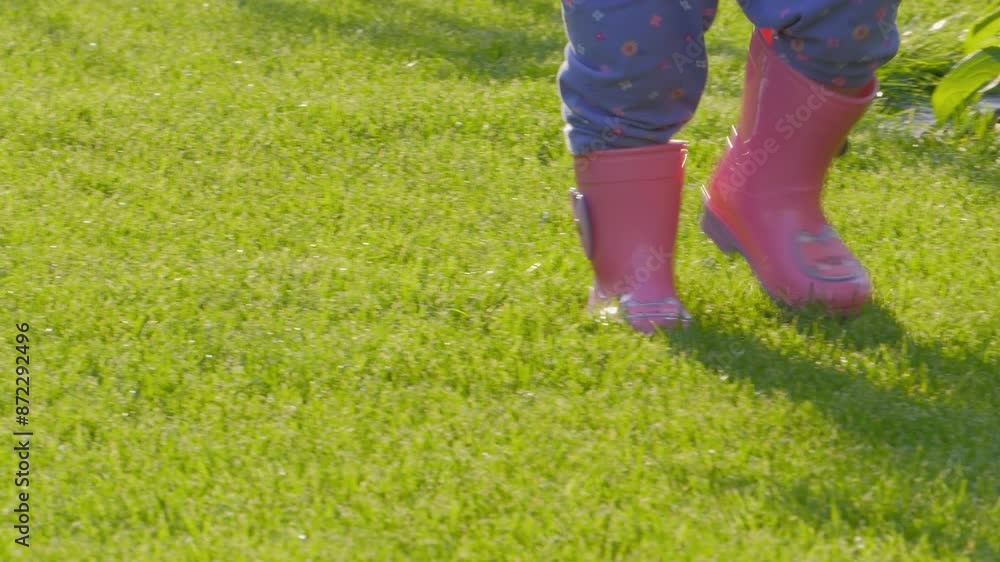 Child in pink rain boots stepping on grass in 4k slow motion 120fps Child in pink rain boots stepping on grass in 4k slow motion 120fps