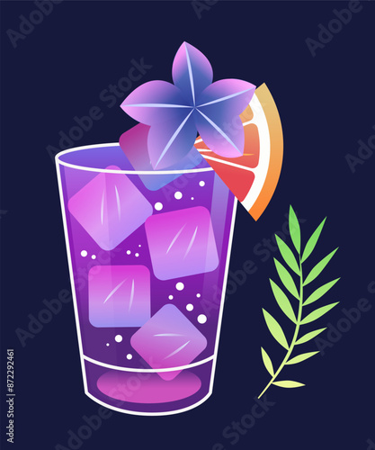 Colorful cocktail glass with ice cubes and flower garnish next to a green leaf and grapefruit slice on dark background
