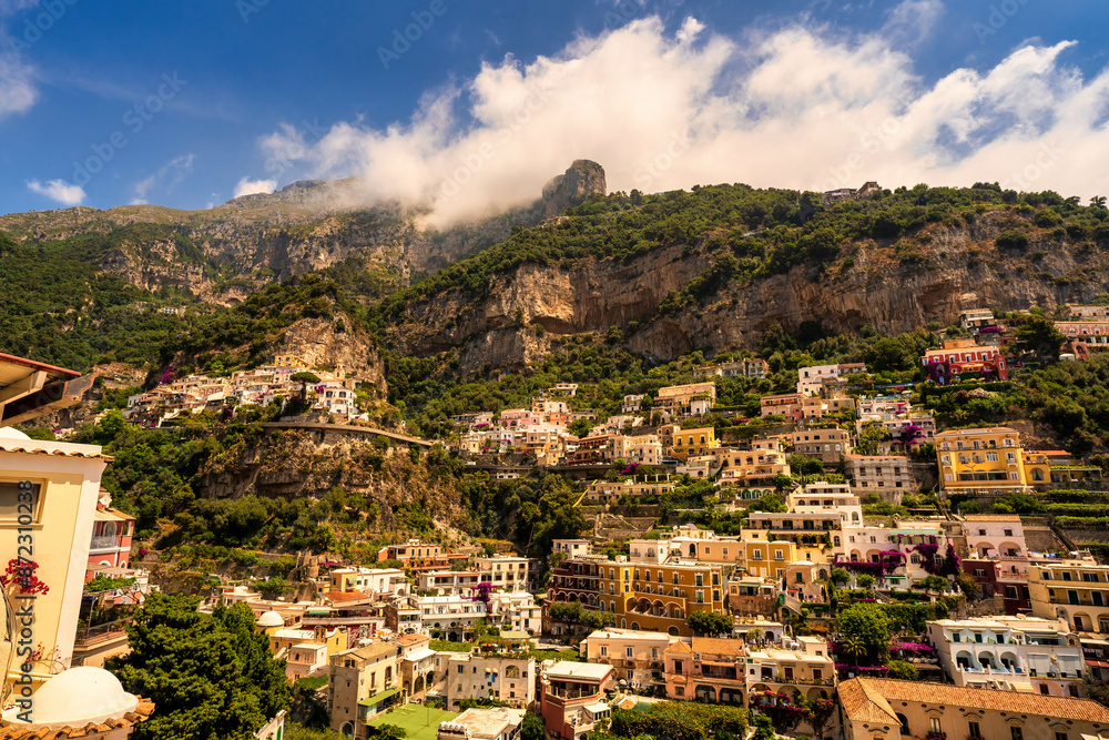 View of Positano village along Amalfi Coast in Italy in summer with cloud formation on top of the hill