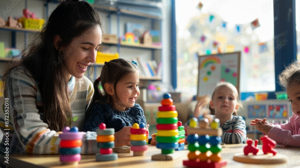 A smiling teacher interacts with preschool kids seated around a table, engaging them in a fun and educational activity in a colorful, well-organized classroom. A smiling teacher interacts with preschool kids seated around a table, engaging them in a fun and educational activity in a colorful, well-organized classroom.