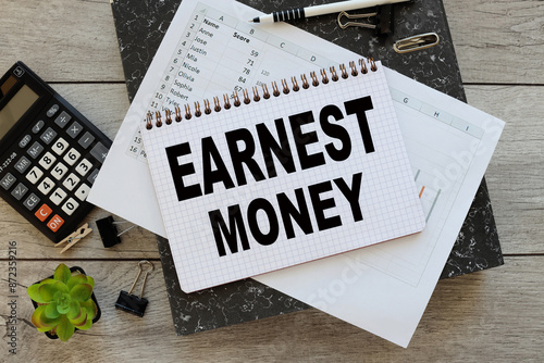 фотографія Earnest money open notepad with text on financial charts