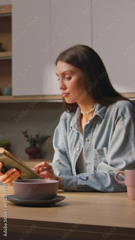 Beautiful Caucasian young woman enjoying reading time in cozy atmosphere. Footage of girl in jeans shirt at home. Morning routine. Time for yourself. Self love concert. Indoors Beautiful Caucasian young woman enjoying reading time in cozy atmosphere. Footage of girl in jeans shirt at home. Morning routine. Time for yourself. Self love concert. Indoors