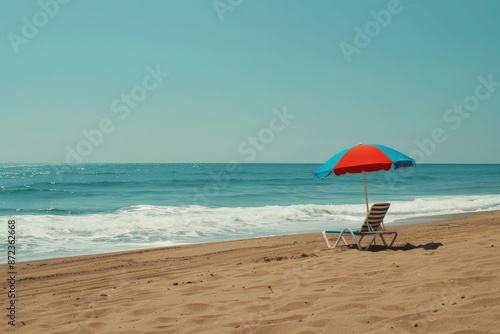 A serene and peaceful beach setting featuring an empty chair under a colorful umbrella, positioned near the edge of the water with clear skies and calm waves.