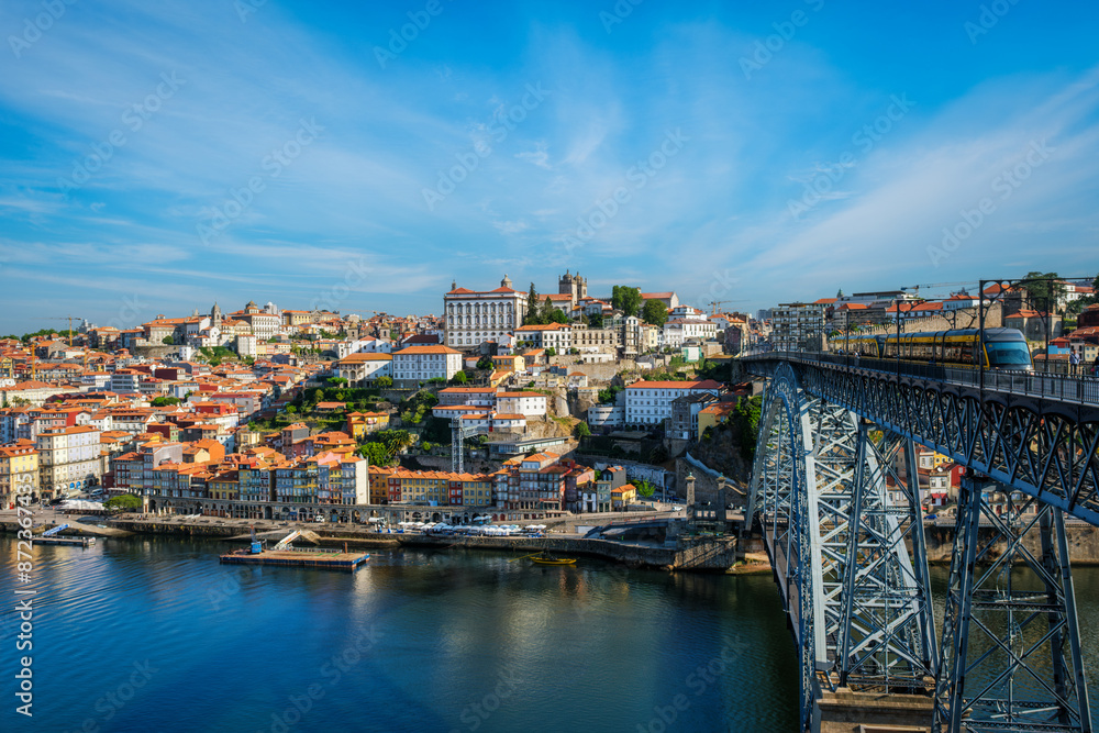 Obraz premium View of Porto city and Douro river and Dom Luis bridge I with metro tram from famous tourist viewpoint Miradouro do Jardim do Morro. Porto, Vila Nova de Gaia, Portugal