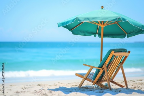 A serene beach scene featuring a wooden chair under a large green umbrella on the sand, with the blue ocean in the background, evoking feelings of relaxation and escape.