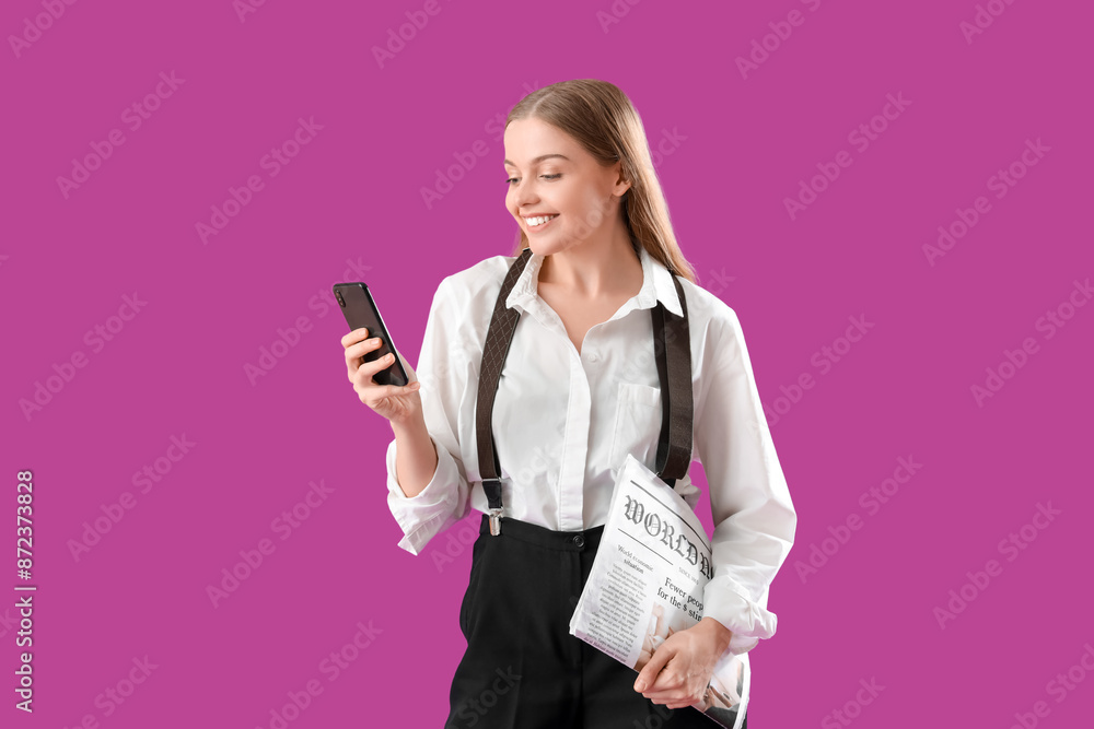 Stylish young businesswoman with newspaper using mobile phone on purple background Stylish young businesswoman with newspaper using mobile phone on purple background