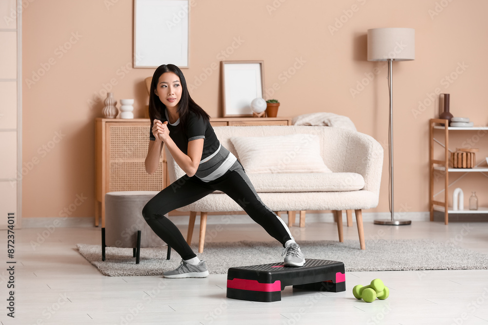 Sporty young Asian woman training with stepper at home Sporty young Asian woman training with stepper at home
