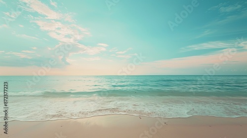 A serene scene of calm ocean waves gently washing up on a sandy beach, under a soft sunset sky. The tranquil color palette creates a peaceful and relaxing atmosphere. © Eleanor Richards