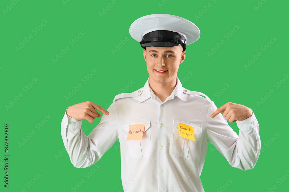 Male pilot pointing at reminders on green background
