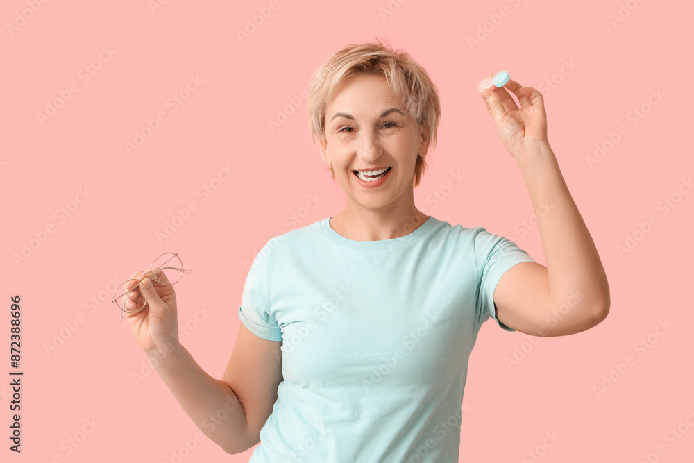 Mature woman with contact lens case and eyeglasses on pink background Mature woman with contact lens case and eyeglasses on pink background