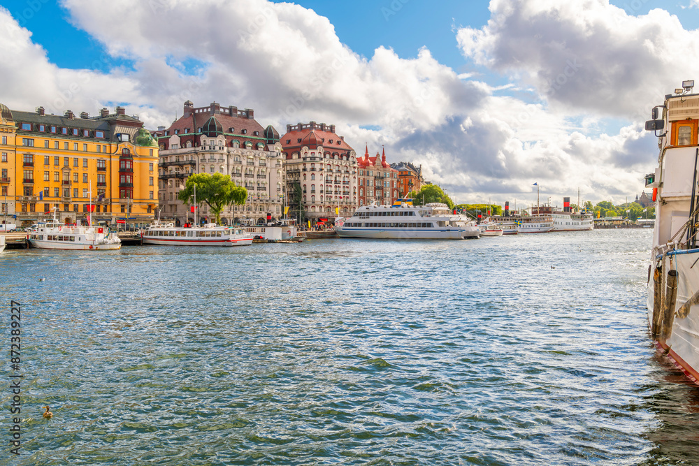 Fototapeta premium Colorful buildings along the waterfront Strandvagen street with boats docked along the marina in the city center of Stockholm, Sweden.